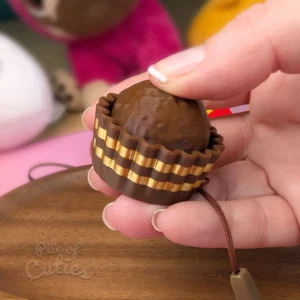 Chocolate praline clicker keychain showing the click action