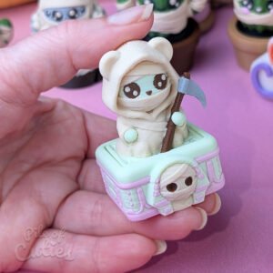 Close-up of a finger pressing down on the cute Grim Reaper clicker for a satisfying fidget action
