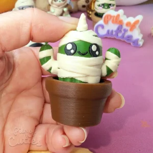 A finger pressing down on the 3D printed unicorn cactus fidget clicker in motion