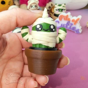 3D printed unicorn cactus clicker sitting in a mini pot