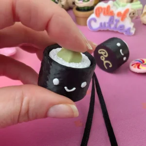 3D printed wasabi sushi fidget clicker being pressed by hand, showing the satisfying clicker mechanism in use